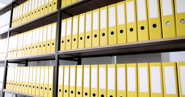 Книжкова шафа з великою кількістю жовтих тек з документами в архіві 4k фільм повільний рух. Зберігання важливої інформаційної концепції
 - Кадри, відео