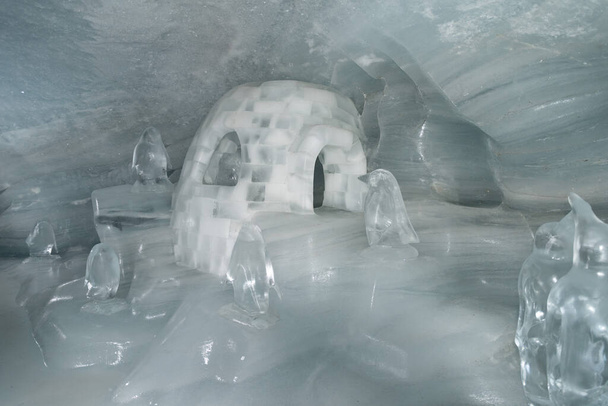 Jungfraujoch, Canton Bern, Suiza, 11 de febrero de 2023 Escultura de hielo de un iglú con pingüinos dentro del palacio de hielo - Foto, Imagen