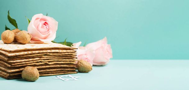 ユダヤ人の休日マツァ、ダビデの星、春の花、青いミントのテーブルの上のクルミと過越の挨拶カードの概念。Seder Pesach春休みの背景、コピースペース. - 写真・画像