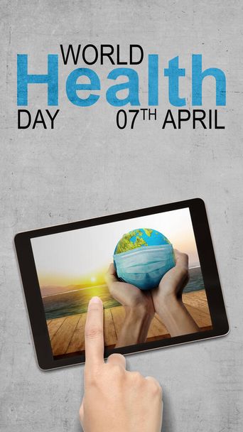 Human hand showing earth with a face mask. World Health Day Concept - Foto, Imagen