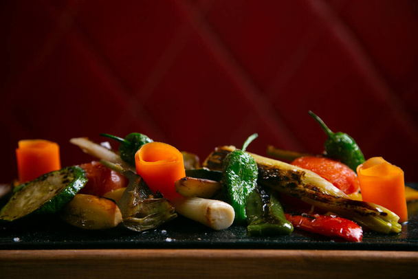 Oven roasted vegetable dish such as carrots, green bell pepper, tomatoes and leeks. - Photo, Image