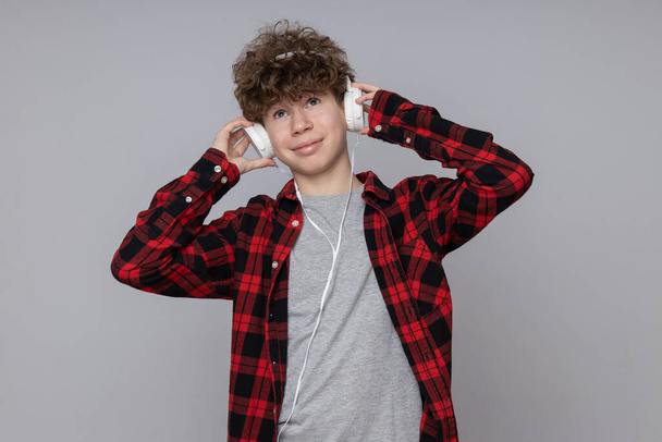 Attractive boy, teenager in headphones on gray background - Фото, изображение
