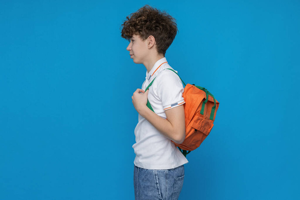 Attractive boy, teenager with backpack on blue background - Foto, immagini