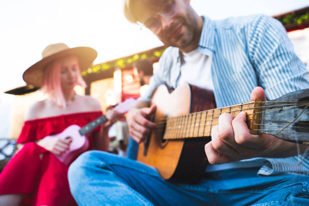 Group of friends have a picnic and play with guitar - Photo, Image