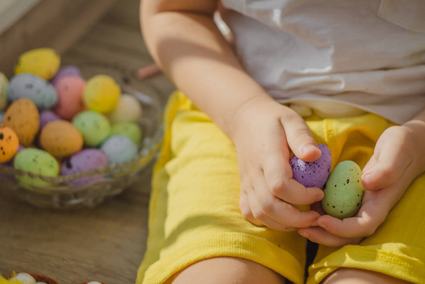 Kids hands with easter eggs with brush in different colors. Close up view. High quality photo - Photo, Image