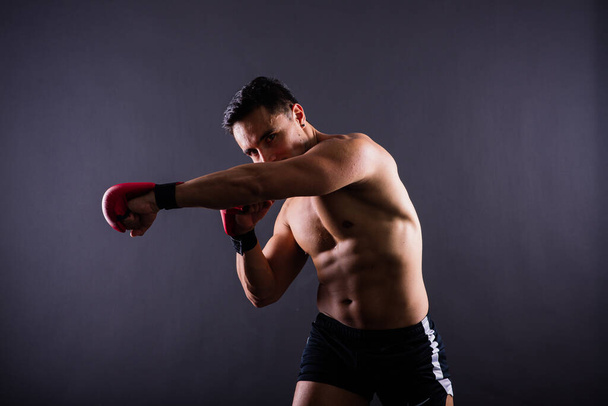 Guanti da boxe, allenamento uomo in una lotta sportiva, sfida o competizione mma su sfondo studio. - Foto, immagini
