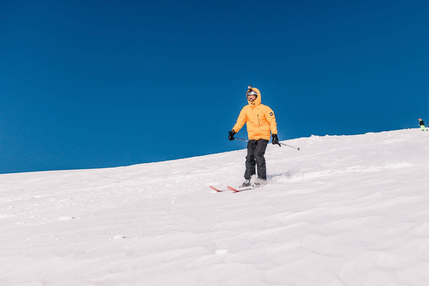 Karpaty, Ukrajina, 8. února2023. Lyžaři a snowboardisté freeride za jasného slunečného počasí na svazích hor u letoviska Dragobrat. Kvalitní fotografie - Fotografie, Obrázek