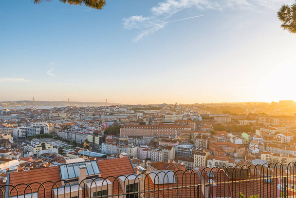 Lisbon, Portugal. Beautiful sunset aerial view of old town of Lisboa city on Tagus river with bridge. Summer vacation destination - Photo, Image