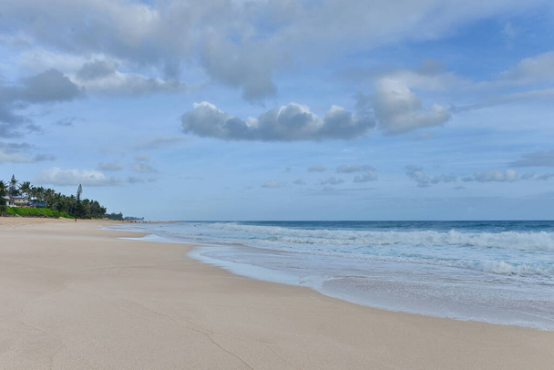 Malowniczy widok na piękną tropikalną plażę wyspy z drobnym złotym piaskiem, spokojnym turkusowym morzem i zielonymi palmami - Zdjęcie, obraz