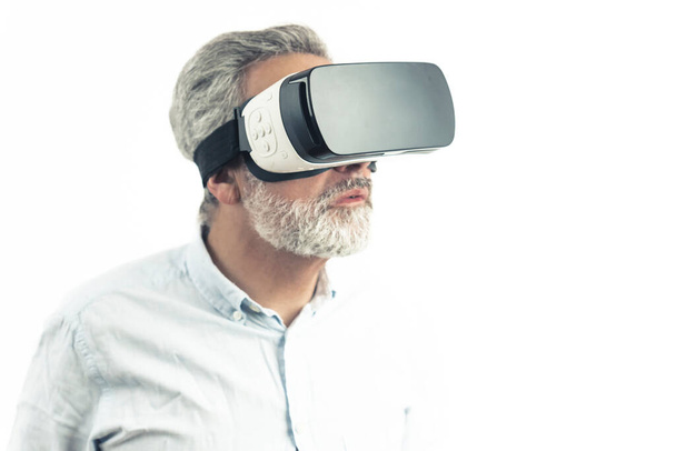 Homem de meia-idade vestindo conjunto Realidade Virtual óculos VR isolados em branco. Foto de alta qualidade - Foto, Imagem