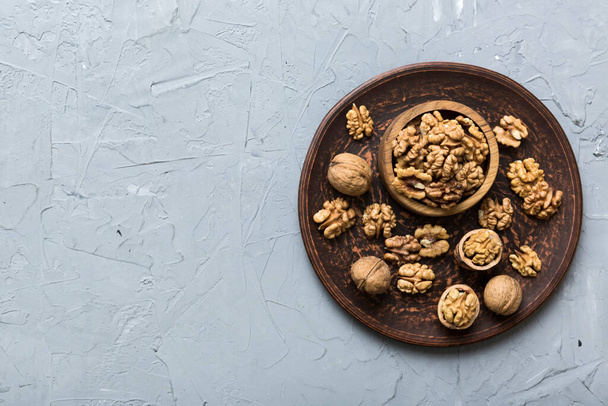 Fresh healthy walnuts in bowl on colored table background. Top view Healthy eating bertholletia concept. Super foods. - Photo, Image