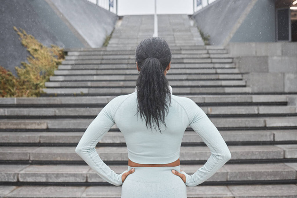 階段、ランニング、黒の女性ランナーのフィットネスは、ワークアウトや動機付きのステップトレーニングの準備ができています。健康的な体のための運動、スポーツ、アスリートの挑戦の前に女性のバックビュー. - 写真・画像