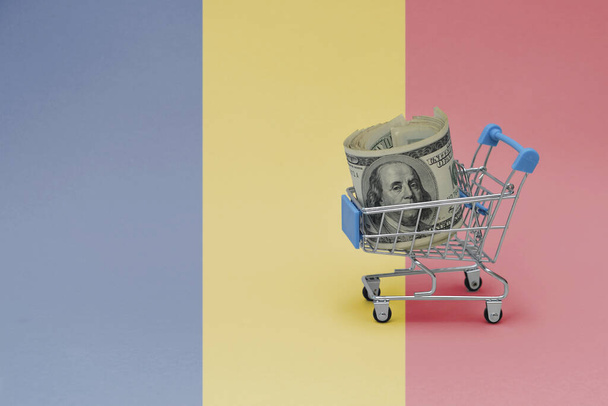 Metallinen ostoskori, jossa on suuren dollarin seteli Romanian lipun alla. kuluttajakorin käsite. 3d kuva - Valokuva, kuva