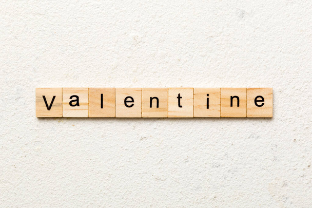 Walentynkowe słowo napisane na drewnianym bloku. Walentynkowy tekst na stole, pojęcie. - Zdjęcie, obraz