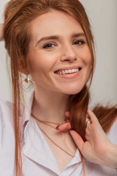 Módní headshot portrét krásy zrzka štěstí žena s roztomilým bílým úsměvem v bílé stylové košili ve studiu - Fotografie, Obrázek