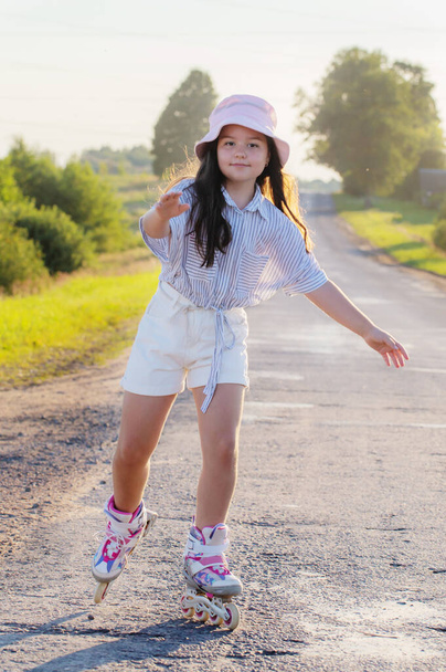 happy girl on roller skates in summer road - Fotoğraf, Görsel