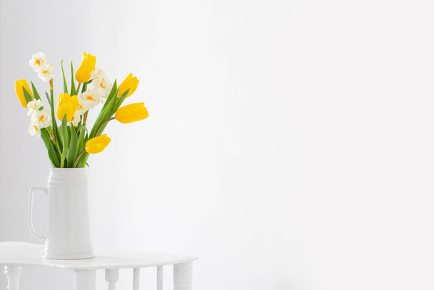 white and yellow spring flowers  in vase on white background - Foto, Imagem