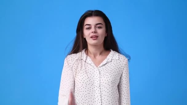 4k video van een meisje dat een luchtkus stuurt op een blauwe achtergrond. Concept van liefde emotie. - Video