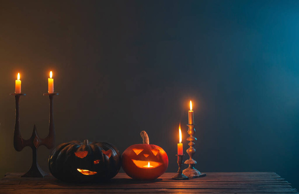 halloween pumpkins with burning candles on dark background - Fotó, kép