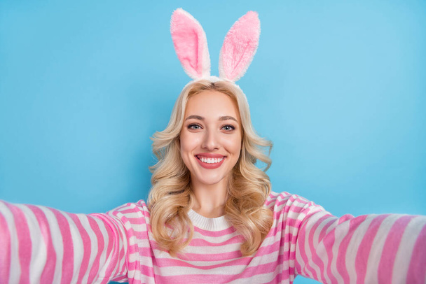 Photo of shiny cute woman wear striped sweater bunny headband recording self video isolated blue color background. - Photo, Image