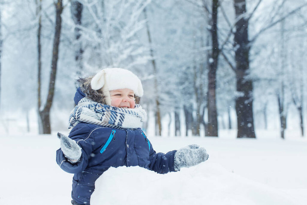 little happy boy in snowy winter park - Zdjęcie, obraz