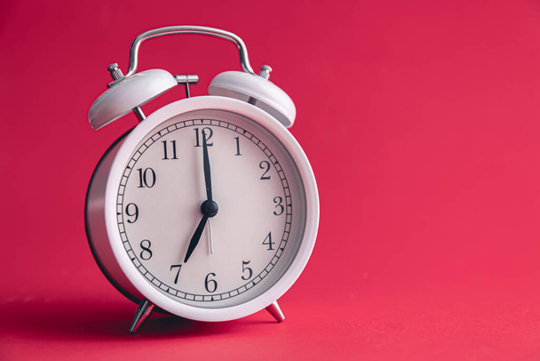 White alarm clock on Viva Magenta color background, copy space. - Фото, изображение