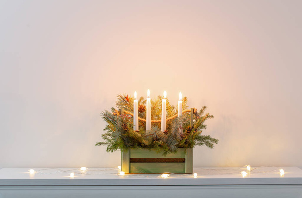 advent decoration with fir branches and four burning candles in wooden basket on white background - Φωτογραφία, εικόνα