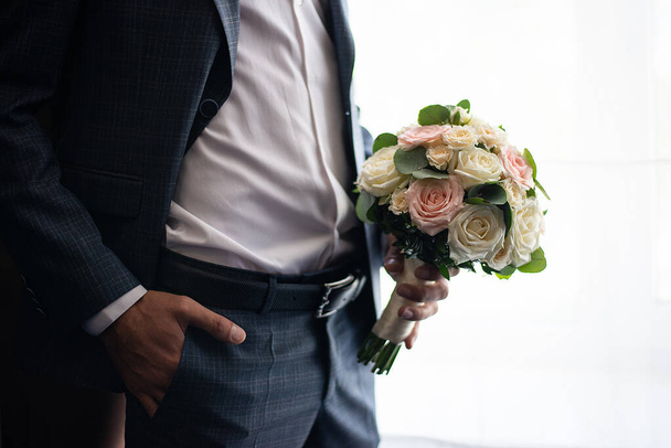 wedding bouquet in the hands of the groom. concept for event agencie - Фото, изображение