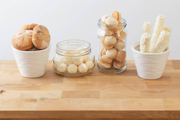 candies and cookies  in jars on wooden shelf on white background - Foto, Bild