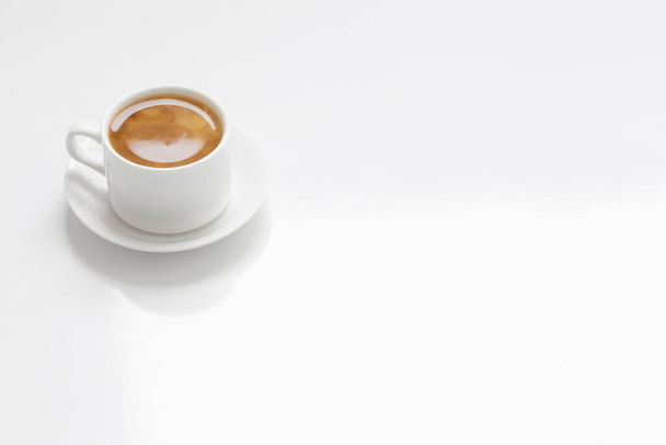 Біла чашка кави на білому столі
 - Фото, зображення