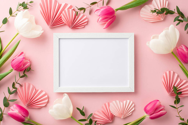 Koncept Dne matek. Nahoru pohled fotografie fotografie rámečků tulipánů a origami papírových srdcí na izolovaném pastelově růžovém pozadí s copyspace - Fotografie, Obrázek