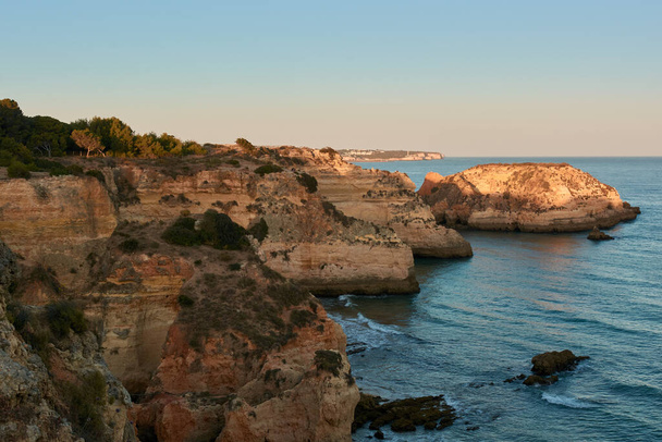 Espectacular color de las rocas calizas al atardecer. Vista desde la ruta de trekking entre Portimao y Alvor. Región del Algarve, Portugal - Foto, imagen