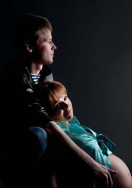 Pregnancy pair in studio dark, low key. Lifestyle, expectation - Fotó, kép