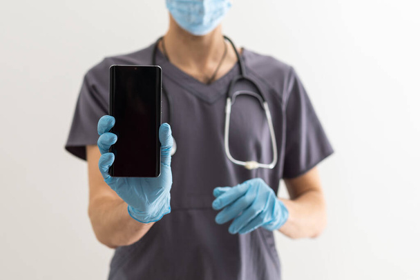 Lekarz trzyma telefon komórkowy, Koncepcja e-zdrowia, Koncepcja zdrowia, biały ekran, pokazać coś - Zdjęcie, obraz