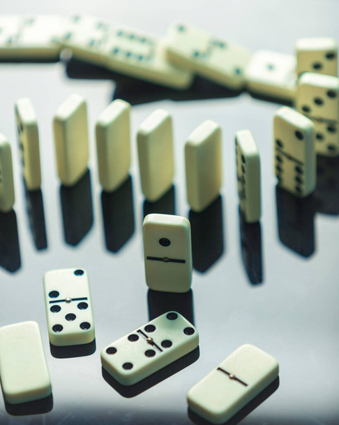 Domino vaikutus liikeideoita, kaksi kappaletta domino harmaalla taustalla negatiivinen tila, strategia ja onnistuneita interventioita, lautapeli, sisätiloissa toimintaa, liiketoiminnan konsultti - Valokuva, kuva