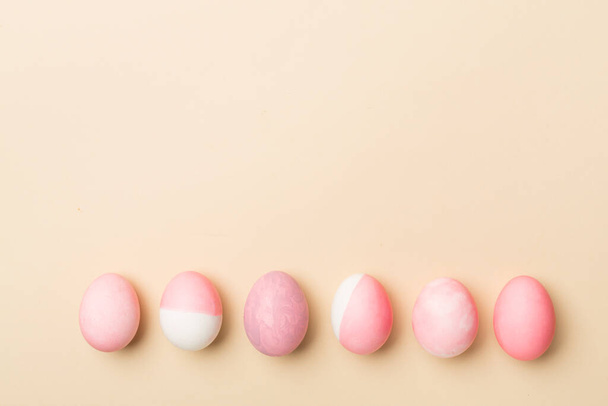 Розовые пасхальные яйца с декором на цветном фоне, вид сверху - Фото, изображение