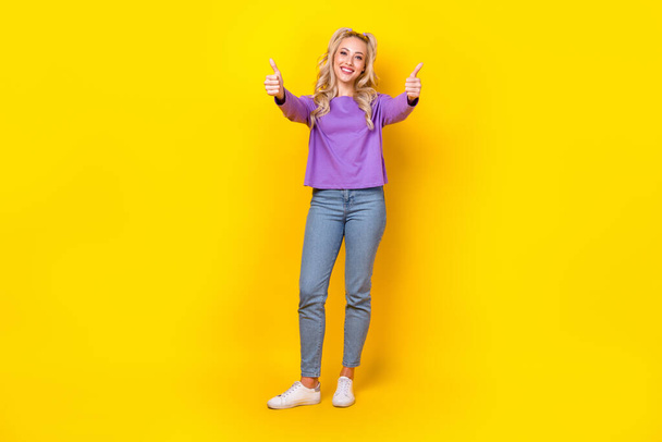 Volledige lengte foto van mooie jonge dame handen winkelen dubbele duim omhoog gekleed stijlvol violet kledingstuk geïsoleerd op gele kleur achtergrond. - Foto, afbeelding
