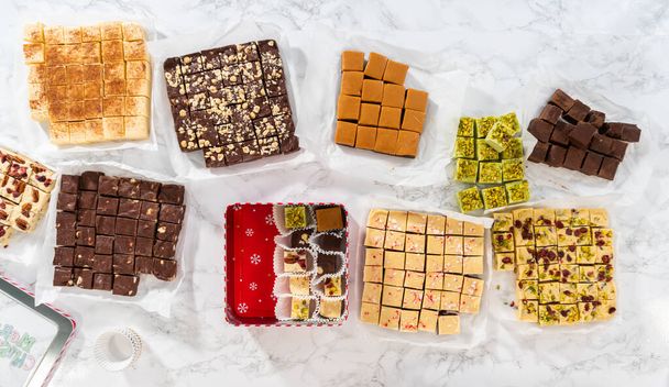Flat lay. Packaging a homemade variety of fudge for Christmas food gifts into tin boxes. - Foto, afbeelding
