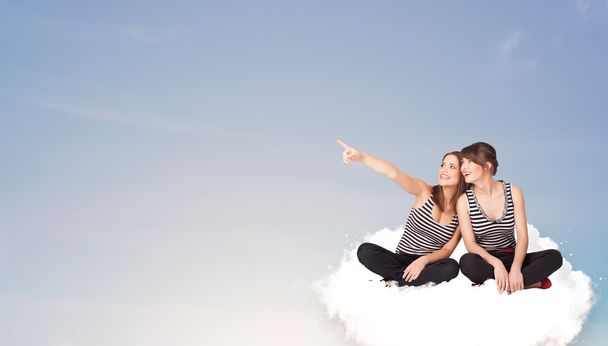 Nuoret naiset istuu pilvi kopioi tilaa - Valokuva, kuva