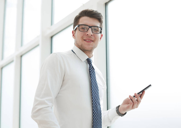 Businessman using smart phone in blurred office space background and copy space - Zdjęcie, obraz