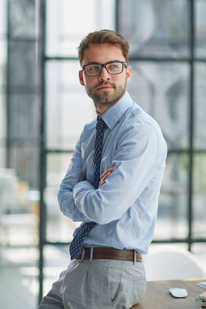 Young cheerful businessman working at office - Fotoğraf, Görsel