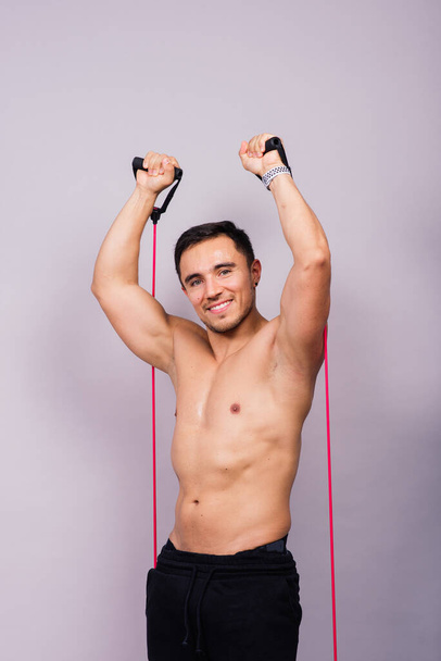 Athletic man skipping with jump rope on grey background. Best cardio workout - Foto, Imagem