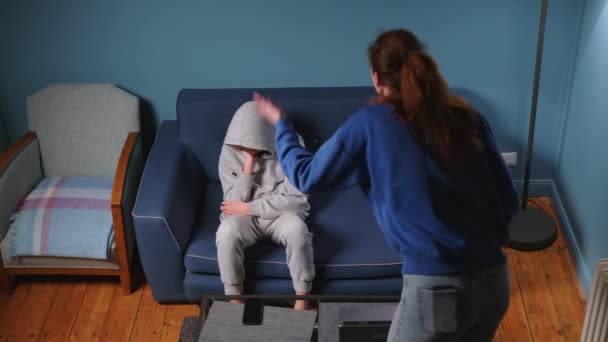 Mamá grita y regaña a su hijo en la habitación del sofá azul. Mujer irritada enseña una lección a un adolescente. El chico tiene una adolescencia difícil. Abuso infantil en la familia. Imágenes de alta calidad 4k - Imágenes, Vídeo