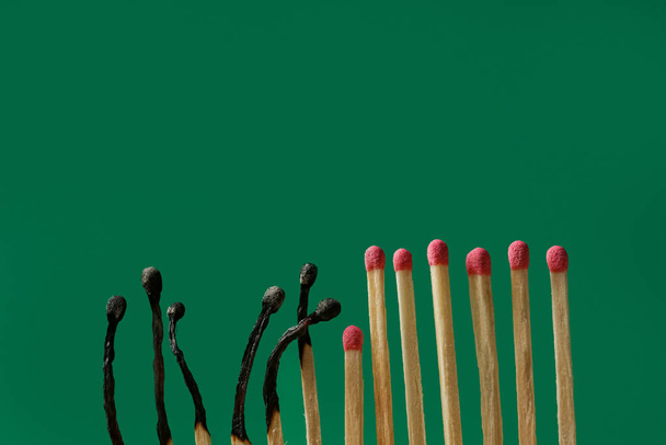 Burnt and whole matches on green background, space for text. Stop destruction concept - Фото, зображення