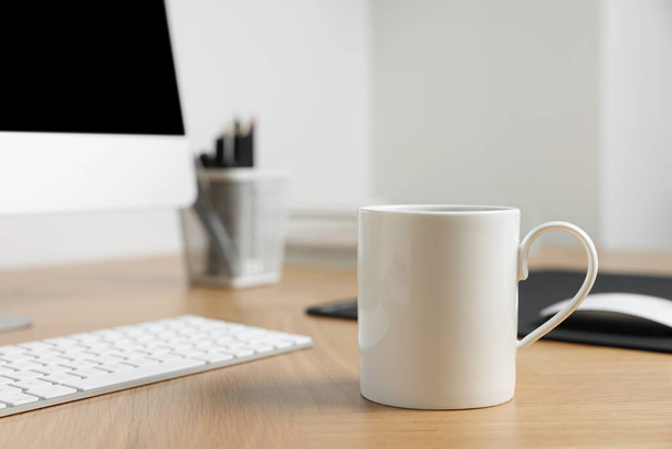 Blank ceramic mug on wooden table. Mockup for design - Photo, image