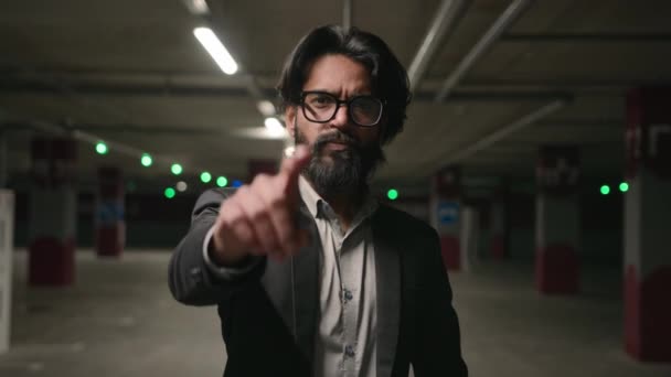 Close-up serious Indian man HR manager choosing candidate for job point finger at camera making inviting come here beckoning gesture ethnic young businessman standing in underground parking welcoming - Кадры, видео