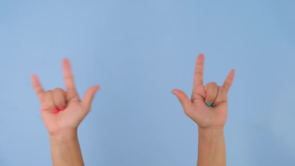 Γυναικείο χέρι που δείχνει το I Love You υπογράφετε απομονωμένο σε παστέλ μπλε φόντο στο στούντιο. Κινήσεις χειρονομιών και γλώσσα του σώματος. Ερωτικό χέρι - Πλάνα, βίντεο