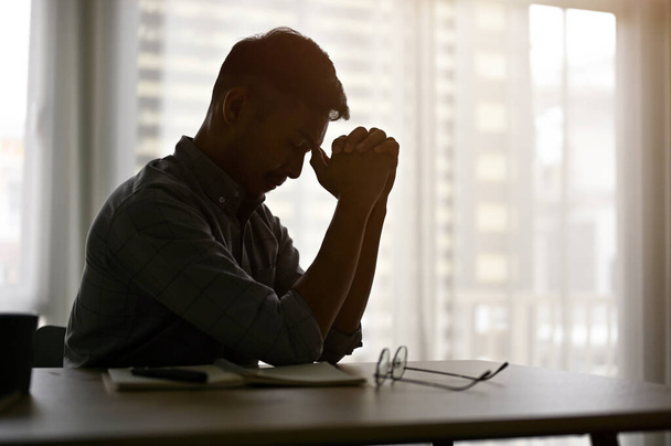 Стрес і пригнічений азіатський чоловік або бізнесмен сидить за столом у темній кімнаті. Силуетний образ - Фото, зображення