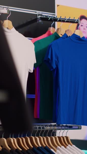 Вертикальное видео: Универмаг массивный шоурум с мерчандайзом от различных брендов одежды, розничный бутик со стильной и повседневной одеждой. Пустой магазин торгового центра, наполненный модным - Кадры, видео