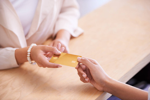 I pagamenti non sono mai stati così facili. Una giovane donna che consegna la sua carta di credito a un venditore - Foto, immagini